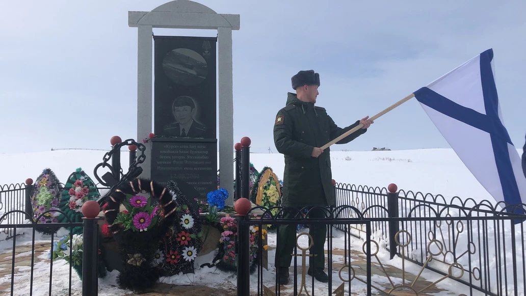 Данис с Андреевским флагом возле памятника отцу в селе Мерясово. Башкортостан, 18 марта 2022 года